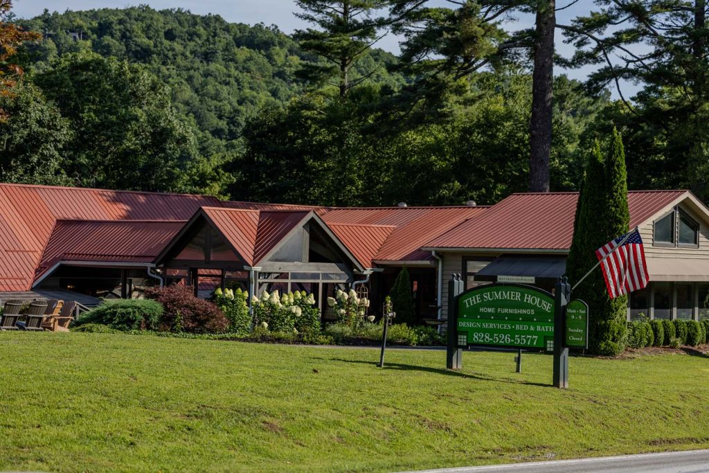 Storefront with red metal roof, green 'The Summer House' sign, and American flag at the entrance.