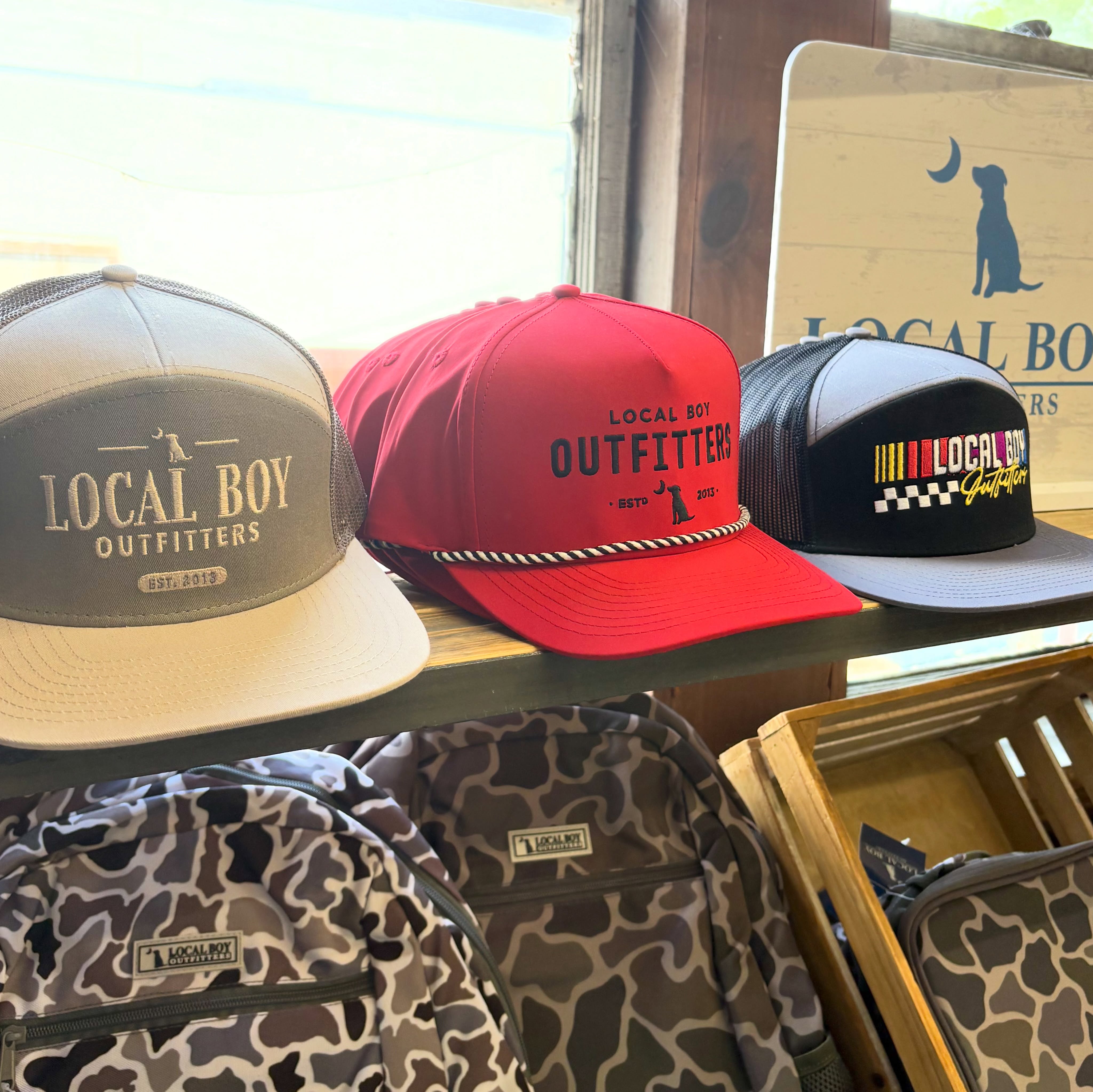 Local Boy Outfitters hats and camouflage backpacks available at Reeves on Main Street in Clayton Georgia