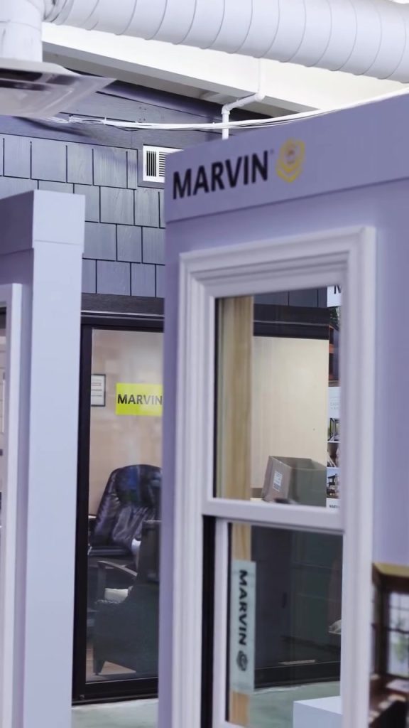 Purple Marvin window-frame sample on display in a showroom, with glass panes and brand visible.